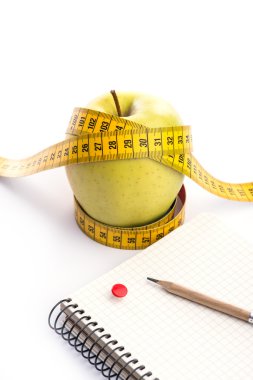 Teyp ve beyaz üstünde defter ölçümleme ile taze ve yeşil organik elma