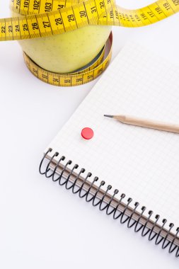 Teyp ve beyaz üstünde defter ölçümleme ile taze ve yeşil organik elma