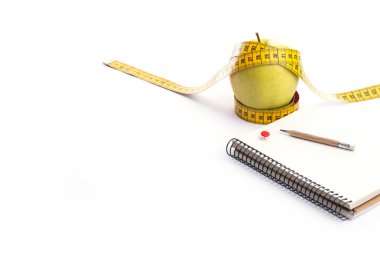 Teyp ve beyaz üstünde defter ölçümleme ile taze ve yeşil organik elma