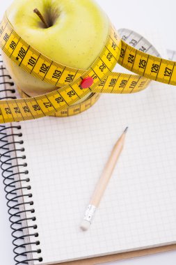 Teyp ve beyaz üstünde defter ölçümleme ile taze ve yeşil organik elma