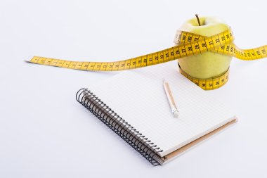 Teyp ve beyaz üstünde defter ölçümleme ile taze ve yeşil organik elma