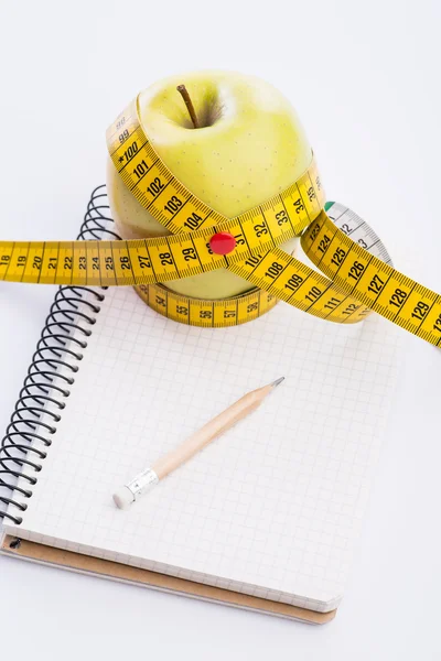 Teyp ve beyaz üstünde defter ölçümleme ile taze ve yeşil organik elma