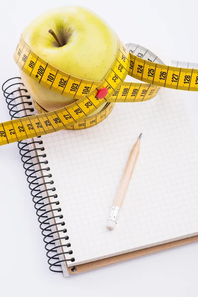 Teyp ve beyaz üstünde defter ölçümleme ile taze ve yeşil organik elma
