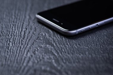 Ahşap bir masa üzerinde siyah akıllı telefon