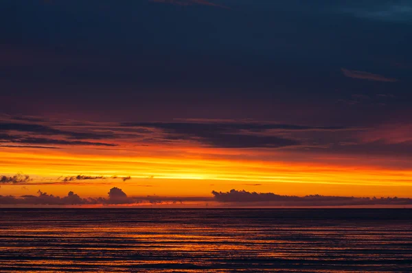 Pôr-do-sol dramático com nuvens pesadas no oceano — Fotografia de Stock