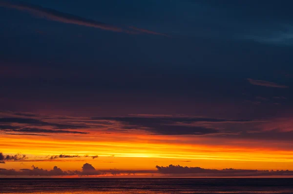 Dramatischer Sonnenuntergang mit dicken Wolken am Meer — Stockfoto