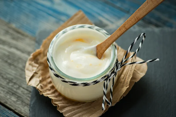 Frasco com iogurte fresco em uma mesa rústica — Fotografia de Stock