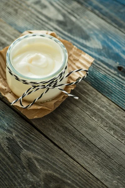 Frasco com iogurte fresco em uma mesa rústica — Fotografia de Stock