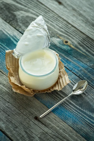 Frasco com iogurte fresco em uma mesa rústica — Fotografia de Stock