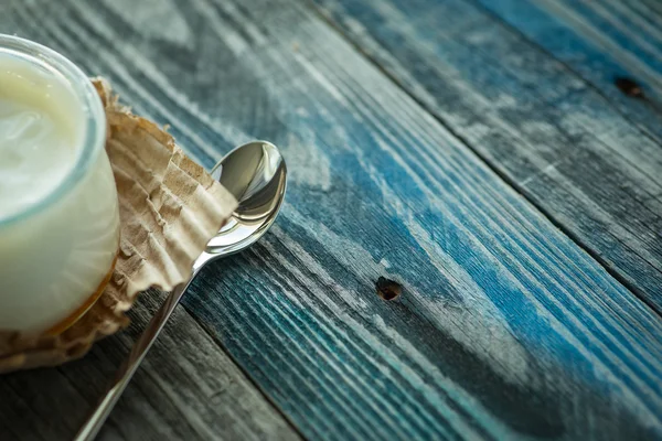 Frasco com iogurte fresco em uma mesa rústica — Fotografia de Stock