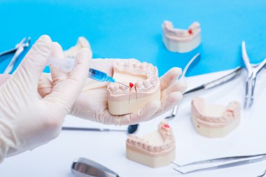 Diş hekimi nasıl enjeksiyon yapılacağını gösterir