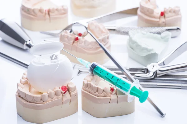 Форма зубов и основные стоматологические инструменты на белом столе — стоковое фото