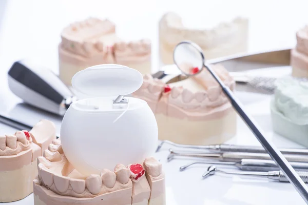 Formy zębów i podstawowe narzędzia stomatologiczne na stół biały — Zdjęcie stockowe