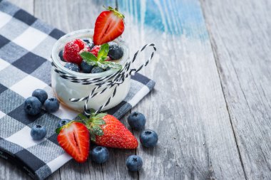 Ahşap masa üzerinde çilek ile taze ve sağlıklı doğal yoğurt