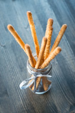 Ev yapımı grisini breadsticks ahşap yüzeyde bir cam kavanoza demet