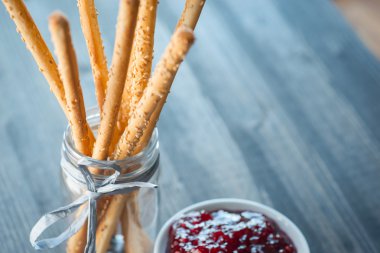 Ev yapımı grisini breadsticks ahşap yüzeyde bir cam kavanoza demet