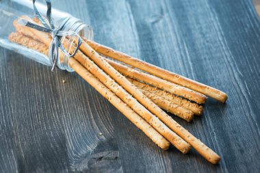 Ev yapımı grisini breadsticks ahşap yüzeyde bir cam kavanoza demet