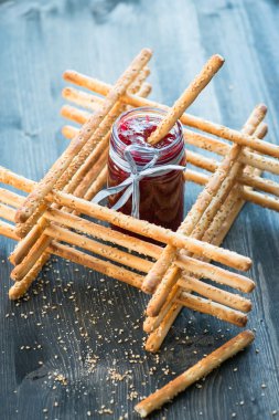 Ev yapımı grisini breadsticks ahşap yüzeyde bir cam kavanoza demet
