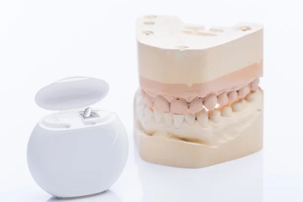 Diş ipi bir parlak beyaz tablo ile diş kalıpları — Stok fotoğraf