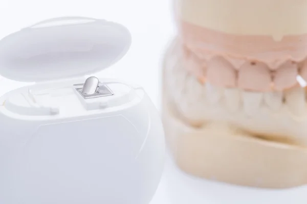 Moldes dentales con hilo dental sobre una mesa blanca brillante — Foto de Stock