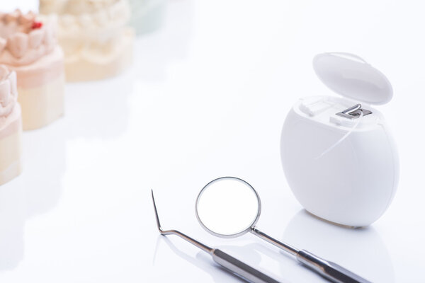 Teeth molds with basic dental tools on a bright white table