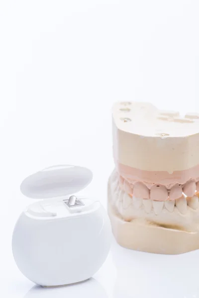 Moules à dents avec fil dentaire sur une table blanche brillante — Photo