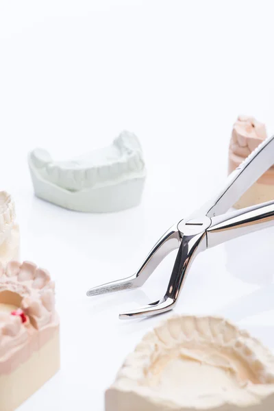 Tanden mallen met tandheelkundige basisinstrumenten op een helder witte tafel — Stockfoto