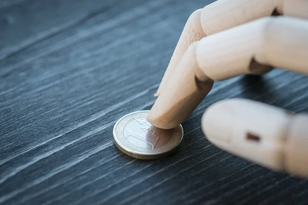 Искусственная деревянная рука, держащая деньги на деревянном столе — стоковое фото