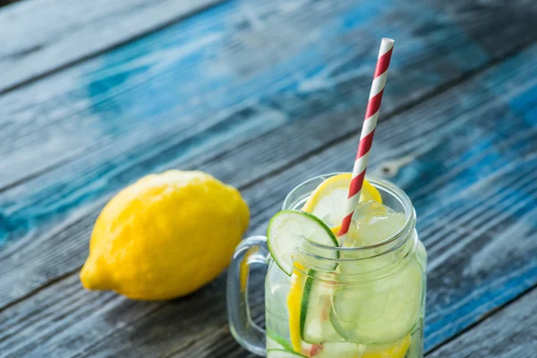 Jar with infused detox water on wooden table