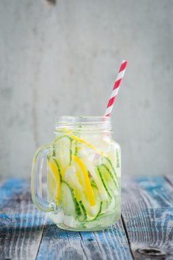 Limon ve su bir rustik ahşap yüzey üzerinde infüzyon salatalık ile sürahi