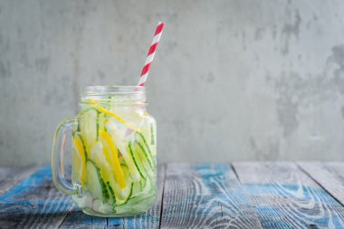 Limon ve su bir rustik ahşap yüzey üzerinde infüzyon salatalık ile sürahi