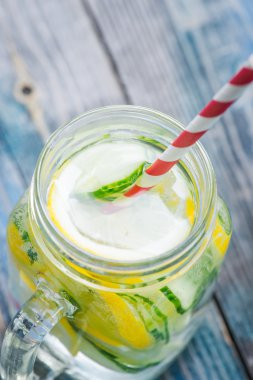 Limon ve su bir rustik ahşap yüzey üzerinde infüzyon salatalık ile sürahi