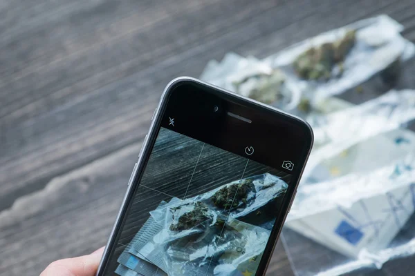 Money and bag with weed on a rustic wooden board