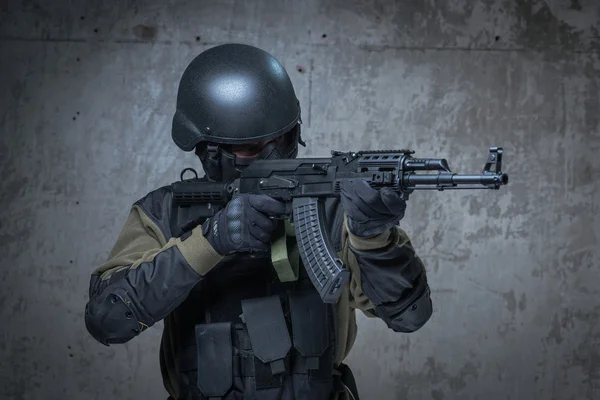 恐怖分子在头盔用自动步枪在手中 — 图库照片
