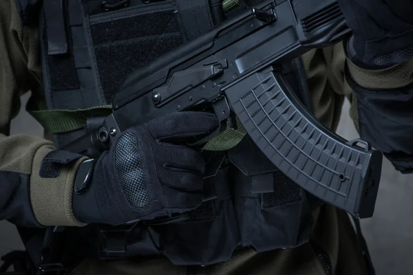Terrorista en guantes con rifle automático en las manos — Foto de Stock