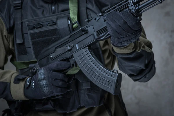 Terrorist in gloves with automatic rifle in hands — Stock Photo, Image