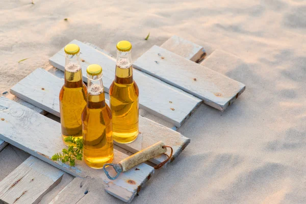 Tre bottiglie di birra in piedi sulla tavola di legno rustico — Foto Stock