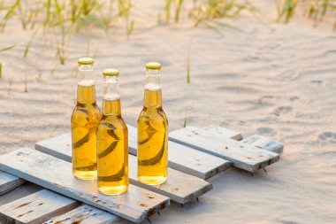 Rustik ahşap tahta üzerinde duran üç bira şişeleri