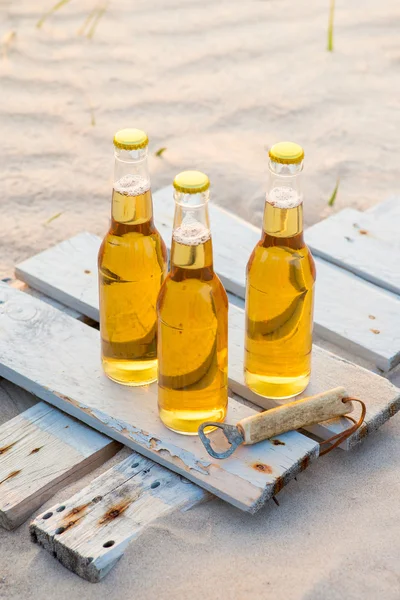 Trois bouteilles de bière debout sur la planche de bois rustique — Photo