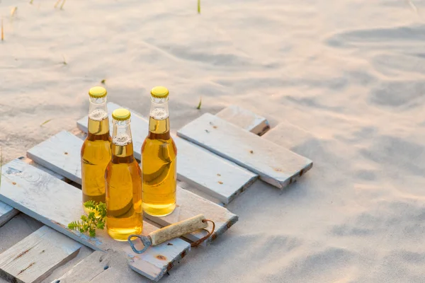 Tre bottiglie di birra in piedi sulla tavola di legno rustico — Foto Stock