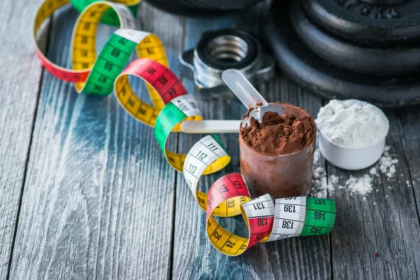 Protein tozu rustik ahşap masa üzerinde klasik halterle