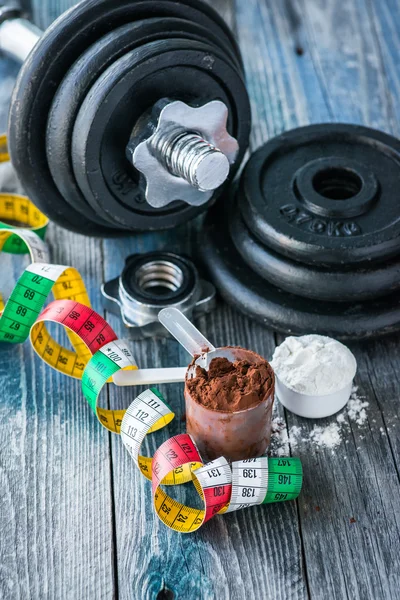 Protein tozu rustik ahşap masa üzerinde klasik halterle