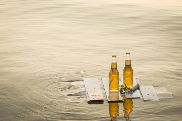 Bouteilles de bière flottant sur la planche en bois — Photo