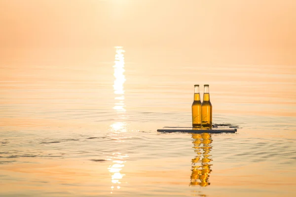 Bottiglie di birra galleggianti sulla tavola di legno — Foto Stock