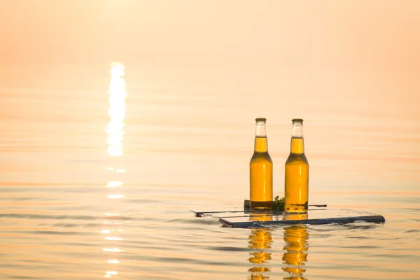 Ahşap tahta üzerinde yüzen bira şişeleri — Stok fotoğraf