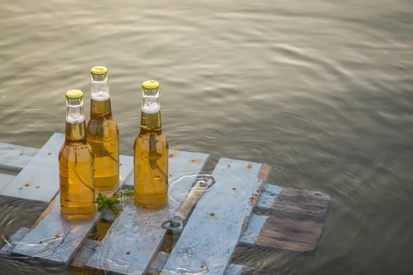 Bouteilles de bière flottant sur la planche en bois — Photo