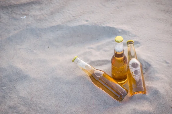 Üç soğuk bira şişeleri kum — Stok fotoğraf