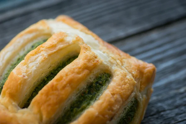 Freshly baked spinach pie on a rustic wooden table — Stock Photo, Image