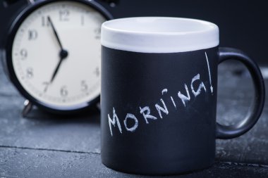 Siyah çay bardağı ile çalar saat ahşap tablo