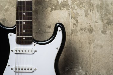 Elektro gitar gri beton duvarının yakınında